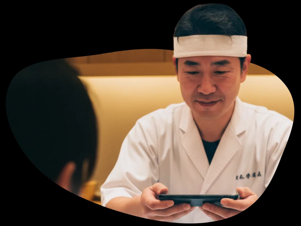 寿司店のスタッフがcoupoでクーポンを確認する様子